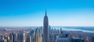 an image showing the top of some nyc skyscrapers with a large sky in background shot just as the day starts to turn to night